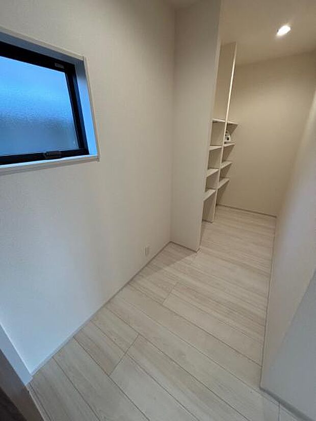 1号棟 キッチン背後の収納スペースはパントリーや掃除用品入れとしても使えます。脱衣場にも行き来ができ、動線も◎です。