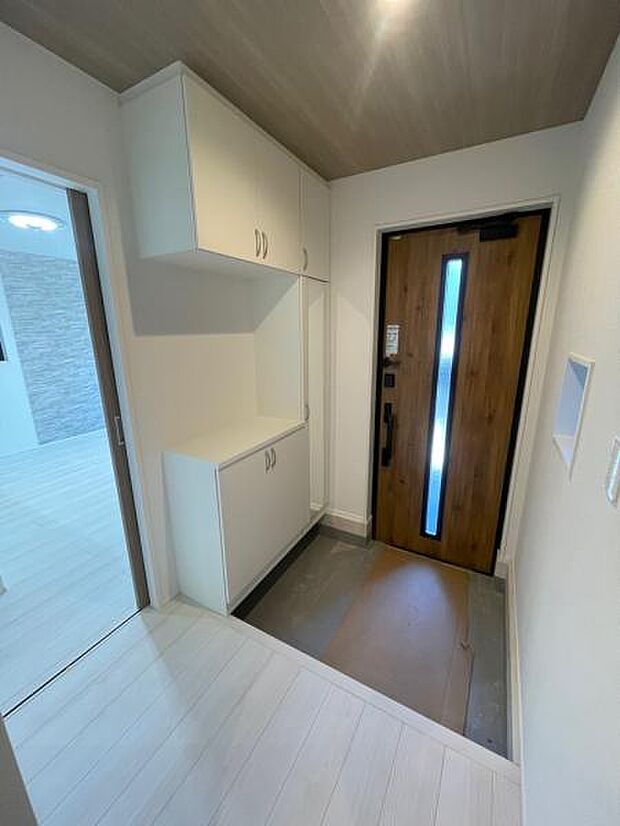 複数人の帰宅でも混雑しない広々した玄関。コの字型のシューズボックスは姿見もついています。