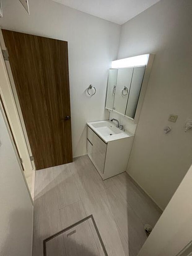 洗面所は洗濯機を置いてもじゅうぶんなスペースがあります。洗面台は人気の三面鏡タイプです。