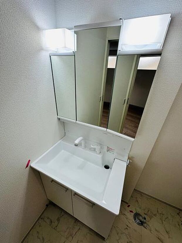 2号棟 人気の三面鏡タイプの洗面台です。鏡の裏にも棚があるので収納豊富です。
