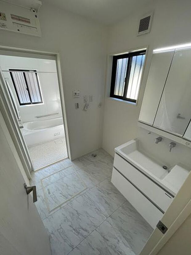 1号棟 洗面所は洗濯機を置いてもじゅうぶんな広さがあります。洗面台は人気の三面鏡タイプです。