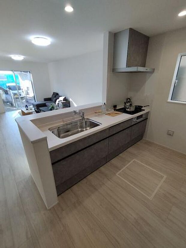 グレー調の使いやすいシステムカウンターキッチン。家族と会話を楽しめます。