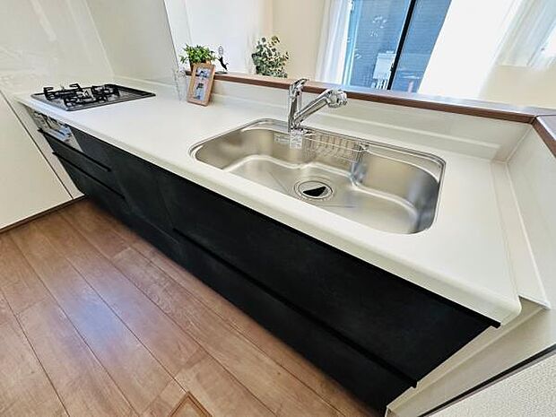 A号棟 ダークブラウンがアクセントのキッチン。オープンタイプで開放感があります。