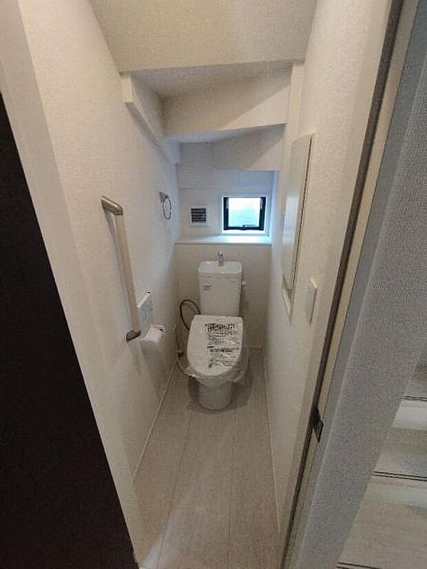 温水洗浄機能つきトイレ。窓や手すり、収納など必要な設備がそろっています。