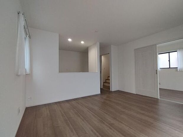 洋室と繋げて使うこともできるリビング。深い落ち着いた色味の床材です。