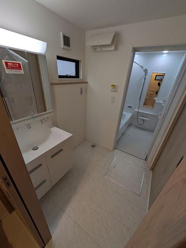 脱衣スペースの様子。洗面台は3面鏡使用で、使い勝手の良さがあります。