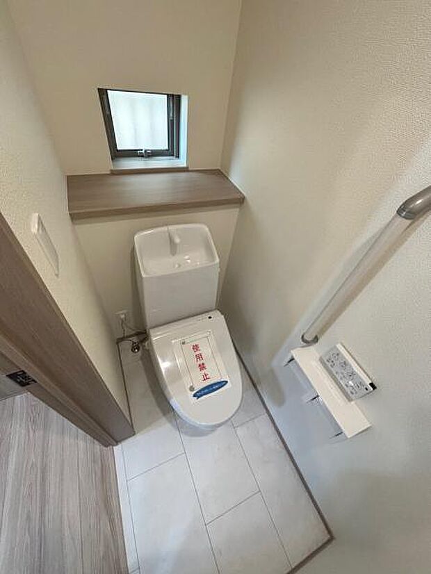 (A号棟) トイレは必要な機能が揃っています。小物も置ける棚が付いていて、収納にも役立ちます。