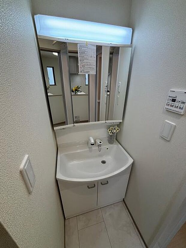 (A号棟) 照明の付いた洗面化粧台。身だしなみも整う3面鏡仕様です。