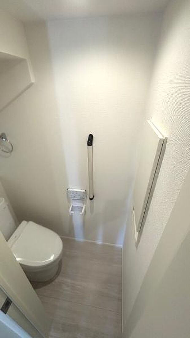 掃除のしやすいシンプルなトイレ。長く住むからこその手すりがありがたいですね。