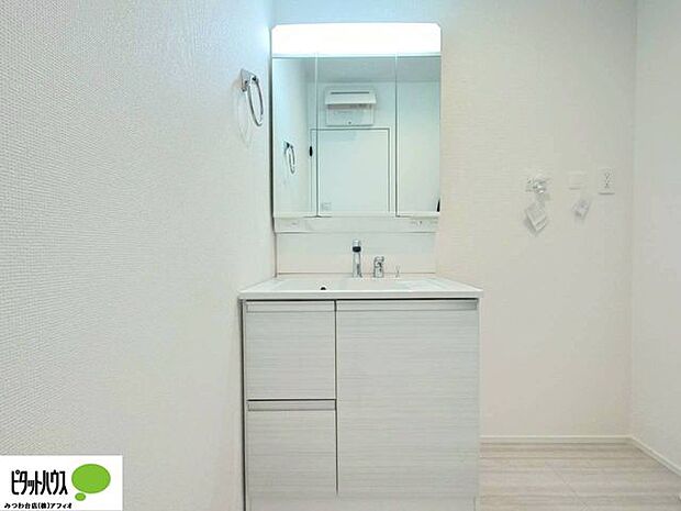 使い勝手のいい三面鏡。24時間換気の換気扇と窓があり清潔感のある洗面室です。