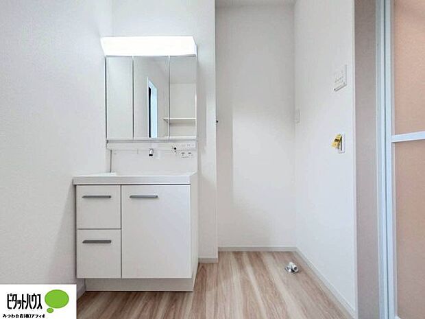 使い勝手のいい三面鏡。24時間換気の換気扇と窓があり清潔感のある洗面室です。