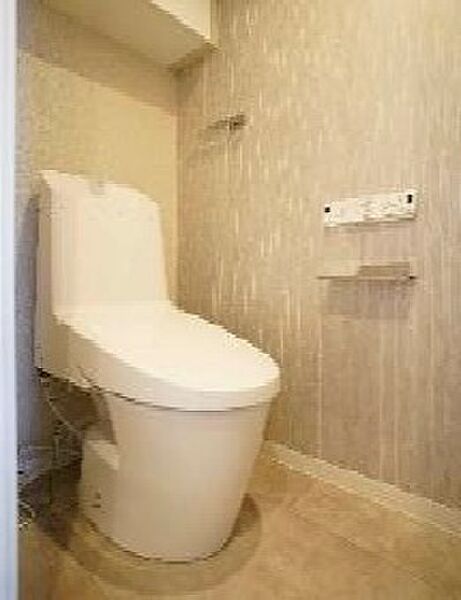 温水洗浄機能付きトイレ。吊戸棚付きでトイレ用品もすっきり収納！