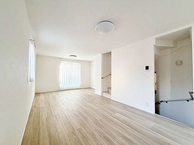 ナチュラルな木目調の床から木のぬくもりを感じられる広々としたリビングルーム。