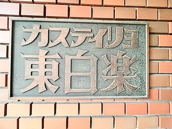 存在感のあるマンション名プレートは、落ち着きのある温かな空間を演出します。家族が笑顔になれる住まいへ。
