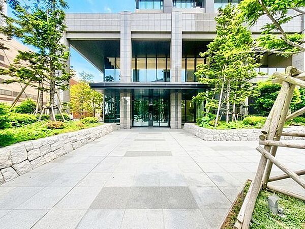 緑が迎え、美しい空間を纏う、洗練されたアプローチ。（空の加工を生成AIで行っています）