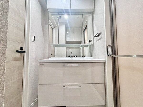 三面鏡の付いた洗面化粧台は、鏡面裏側にも機能的な収納を配置。スキンケア用品などが収納できます。