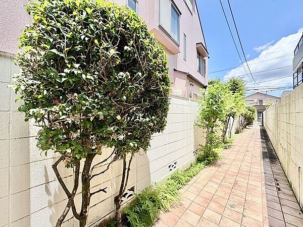 植栽が施されたタイル敷の長いアプローチがお出迎え。
