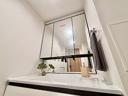 三面鏡の付いた洗面化粧台は、鏡面裏側にも機能的な収納を配置。スキンケア用品などが収納できます。