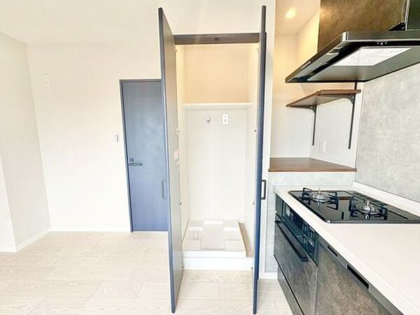生活感が出ないよう、洗濯機を扉の中へ収納しました。収納棚もあって、効率よく家事をこなせます。