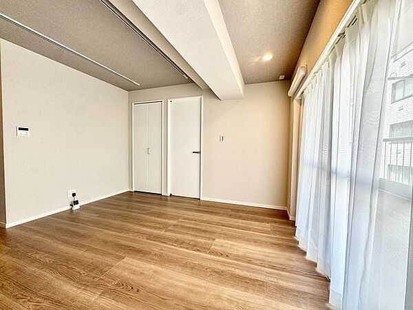 ナチュラルな木目調の床から木のぬくもりを感じられる広々としたリビングルーム。