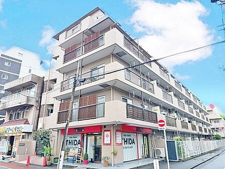 街並みに自然と馴染む色を基調とした外観は、温かみのある色合いが全体を包み、やさしい雰囲気を感じます。(空の加工を生成AIで行っています)
