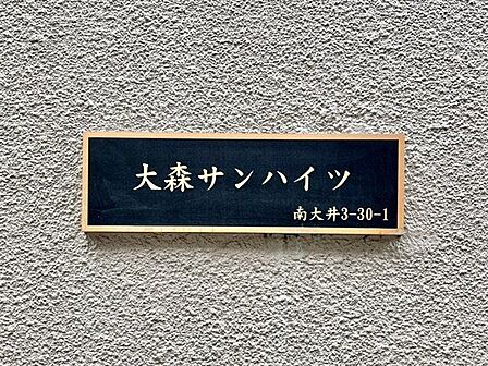 存在感のあるマンション名プレートは、落ち着きのある温かな空間を演出します。家族が笑顔になれる住まいへ。