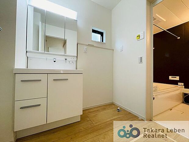 洗面台の横には、防水パン付きの洗濯機置き場があり、家事動線に配慮した配置になっています。