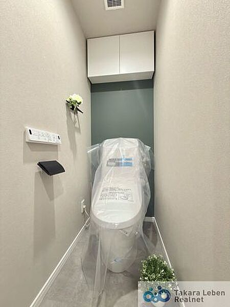 ウォシュレット機能付きのトイレは壁掛けリモコンの上位グレードを採用。便座がスッキリした印象となり、限られた空間を広く見せる効果があります。