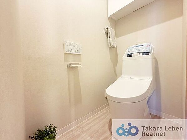 ウォシュレット機能付きのトイレは壁掛けリモコンの上位グレードを採用。便座がスッキリした印象となり、限られた空間を広く見せる効果があります。