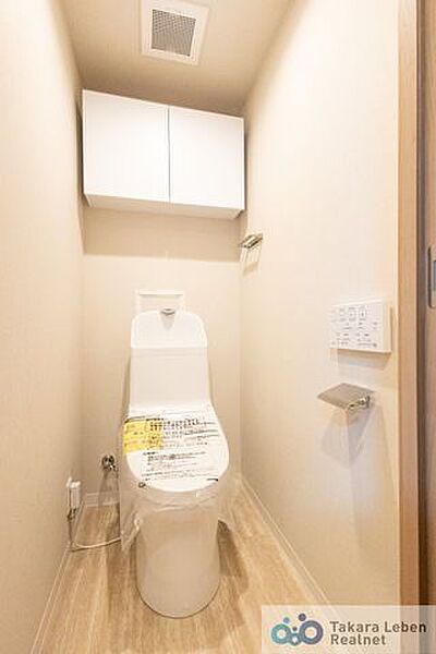 ウォシュレット機能付きのトイレは壁掛けリモコンの上位グレードを採用。便座がスッキリした印象となり、限られた空間を広く見せる効果があります。