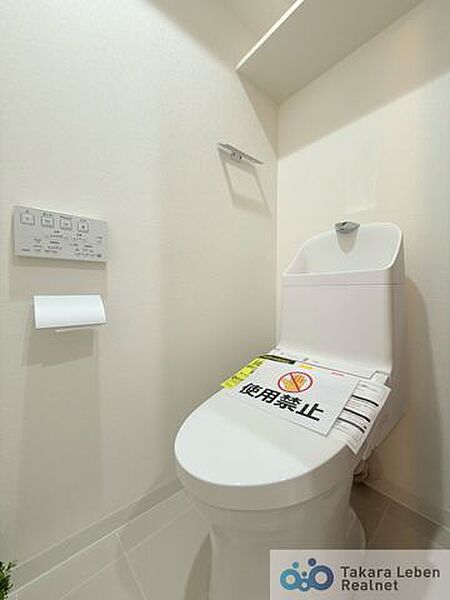 ウォシュレット機能付きのトイレは壁掛けリモコンの上位グレードを採用。便座がスッキリした印象となり、限られた空間を広く見せる効果があります。