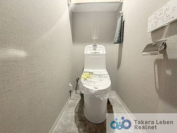 ウォシュレット機能付きのトイレは壁掛けリモコンの上位グレードを採用。便座がスッキリした印象となり、限られた空間を広く見せる効果があります。