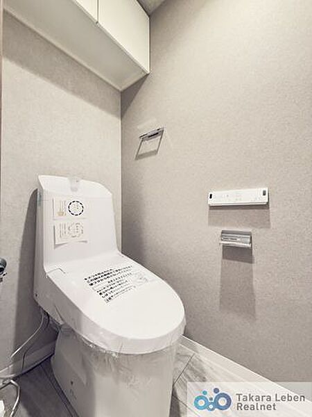 ウォシュレット機能付きのトイレは壁掛けリモコンの上位グレードを採用。便座がスッキリした印象となり、限られた空間を広く見せる効果があります。