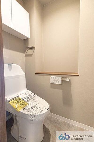 ウォシュレット機能付きのトイレは壁掛けリモコンの上位グレードを採用。便座がスッキリした印象となり、限られた空間を広く見せる効果があります。