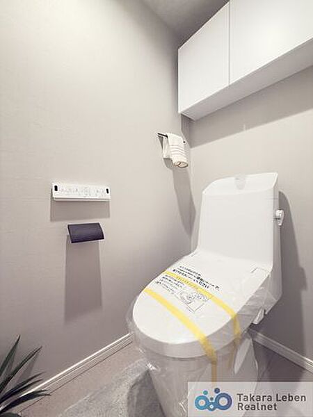 ウォシュレット機能付きのトイレは壁掛けリモコンの上位グレードを採用。便座がスッキリした印象となり、限られた空間を広く見せる効果があります。