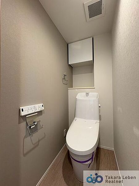 ウォシュレット機能付きのトイレは壁掛けリモコンの上位グレードを採用。便座がスッキリした印象となり、限られた空間を広く見せる効果があります。