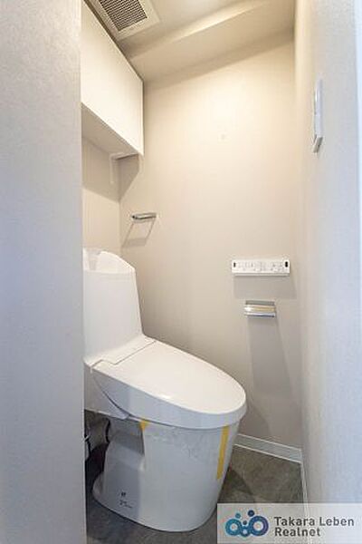 ウォシュレット機能付きのトイレは壁掛けリモコンの上位グレードを採用。便座がスッキリした印象となり、限られた空間を広く見せる効果があります。