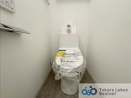 ウォシュレット機能付きのトイレは壁掛けリモコンの上位グレードを採用。便座がスッキリした印象となり、限られた空間を広く見せる効果があります。