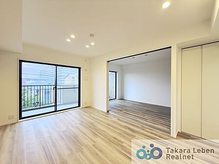 大きな窓からたっぷりと陽光が差し込む明るいリビング。家族が自然と集まり、くつろぎの時間を共有できる心地よい空間です。