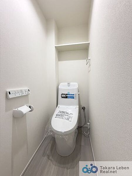 ウォシュレット機能付きのトイレは壁掛けリモコンの上位グレードを採用。便座がスッキリした印象となり、限られた空間を広く見せる効果があります。