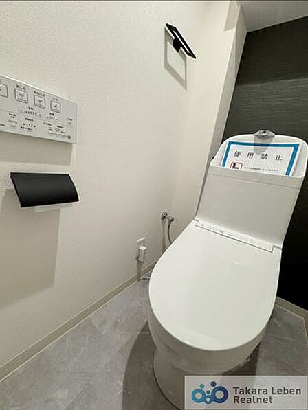 ウォシュレット機能付きのトイレは壁掛けリモコンの上位グレードを採用。便座がスッキリした印象となり、限られた空間を広く見せる効果があります。