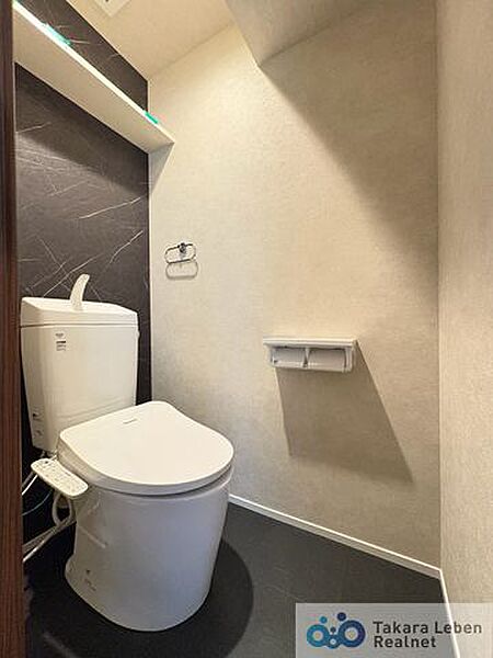 ウォシュレット機能付きのトイレは壁掛けリモコンの上位グレードを採用。便座がスッキリした印象となり、限られた空間を広く見せる効果があります。