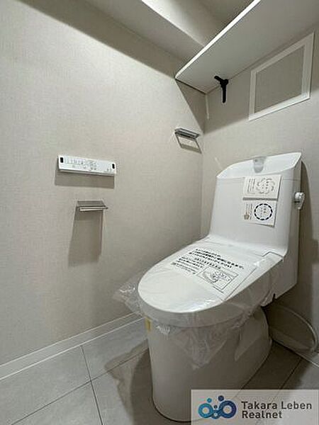 ウォシュレット機能付きのトイレは壁掛けリモコンの上位グレードを採用。便座がスッキリした印象となり、限られた空間を広く見せる効果があります。