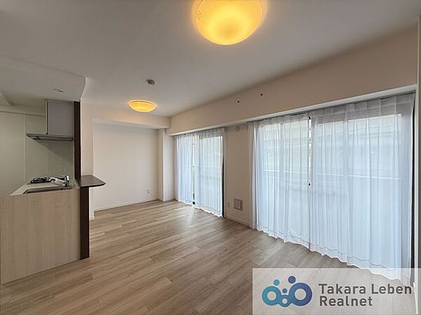 大きな窓からたっぷりと陽光が差し込む明るいリビング。家族が自然と集まり、くつろぎの時間を共有できる心地よい空間です。