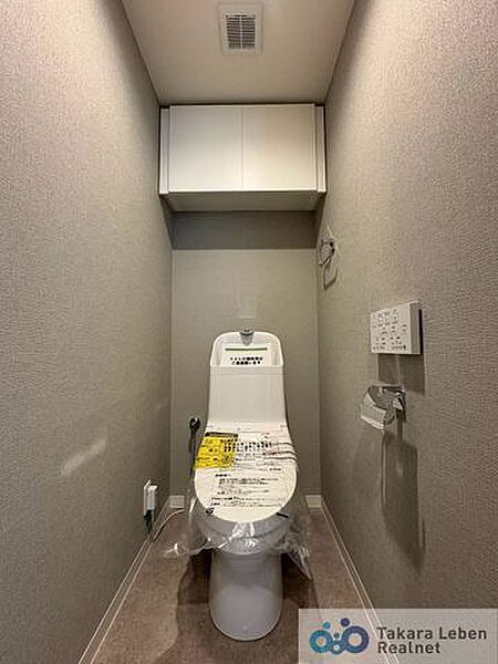 ウォシュレット機能付きのトイレは壁掛けリモコンの上位グレードを採用。便座がスッキリした印象となり、限られた空間を広く見せる効果があります。