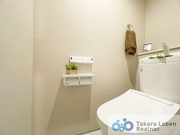 ウォシュレット機能付きのトイレは壁掛けリモコンの上位グレードを採用。便座がスッキリした印象となり、限られた空間を広く見せる効果があります。