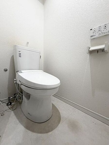 ウォシュレット機能付きのトイレは壁掛けリモコンの上位グレードを採用。便座がスッキリした印象となり、限られた空間を広く見せる効果があります。