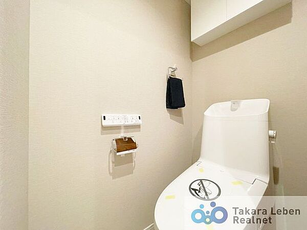 ウォシュレット機能付きのトイレは壁掛けリモコンの上位グレードを採用。便座がスッキリした印象となり、限られた空間を広く見せる効果があります。