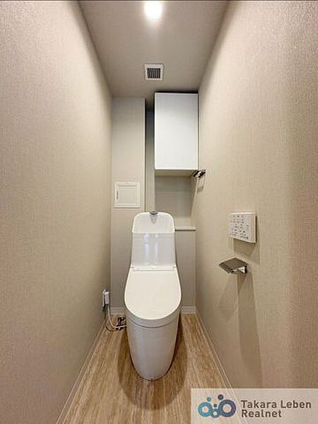 ウォシュレット機能付きのトイレは壁掛けリモコンの上位グレードを採用。便座がスッキリした印象となり、限られた空間を広く見せる効果があります。
