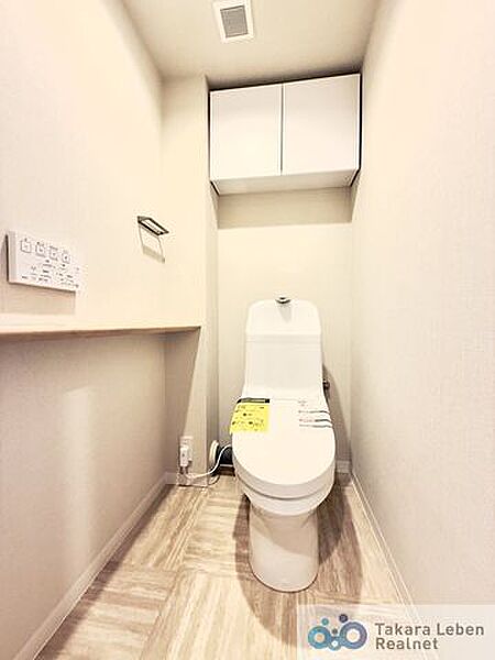 ウォシュレット機能付きのトイレは壁掛けリモコンの上位グレードを採用。便座がスッキリした印象となり、限られた空間を広く見せる効果があります。